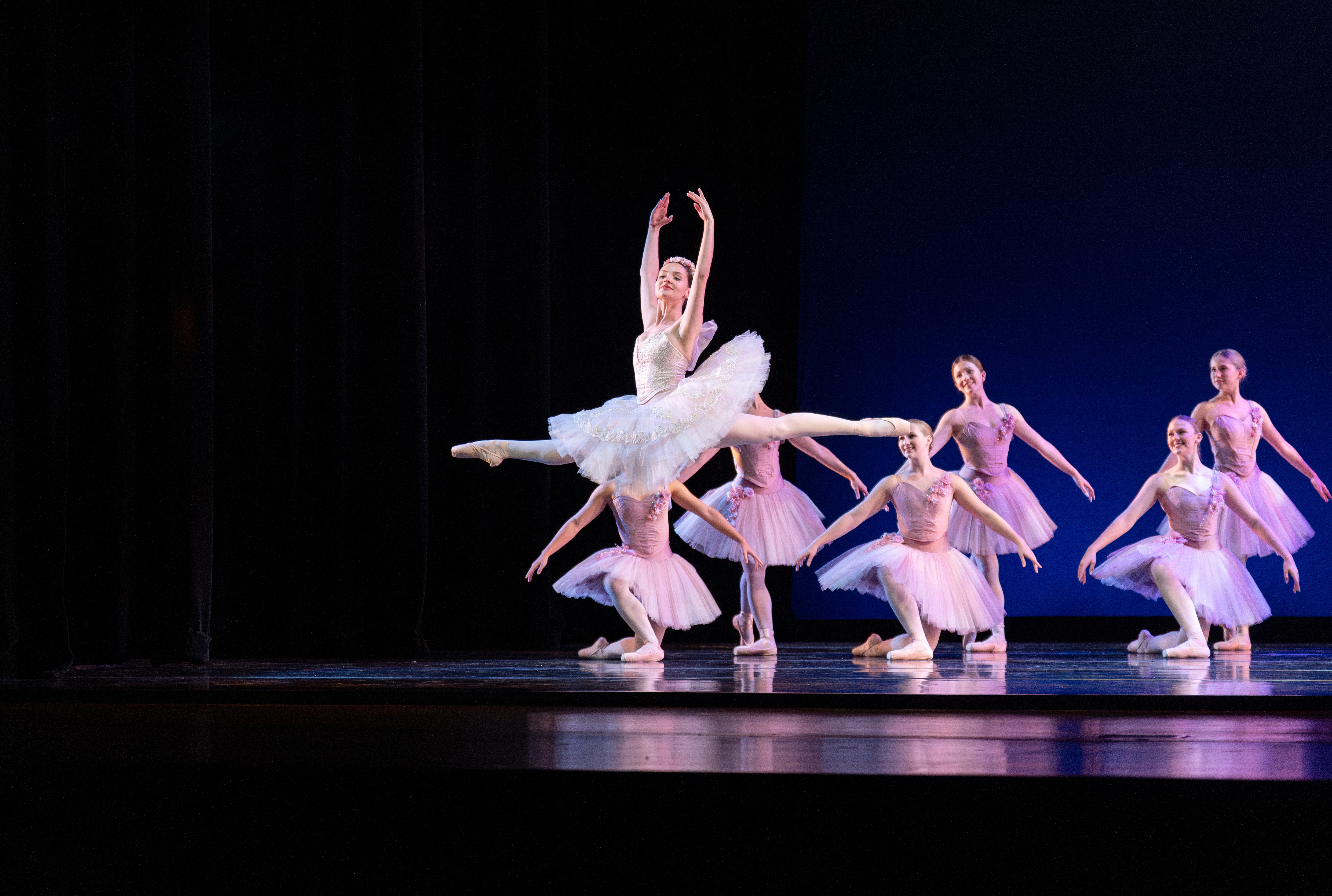 Classical Ballet Dancers on stage, one dancer is leaping high into the air