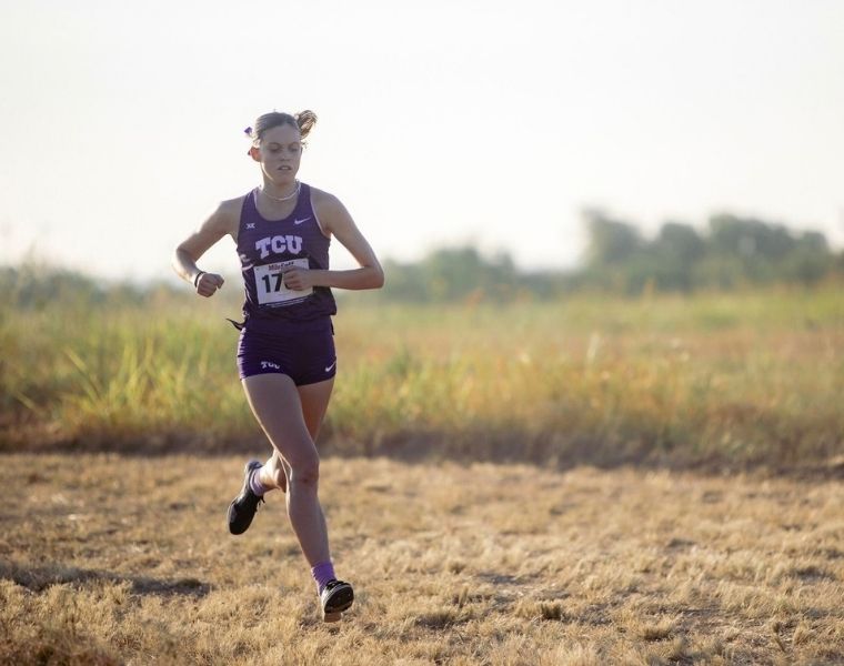 TCU cross country runner and graphic design student McKenzie Bailey competes in a race, wearing a purple TCU uniform.